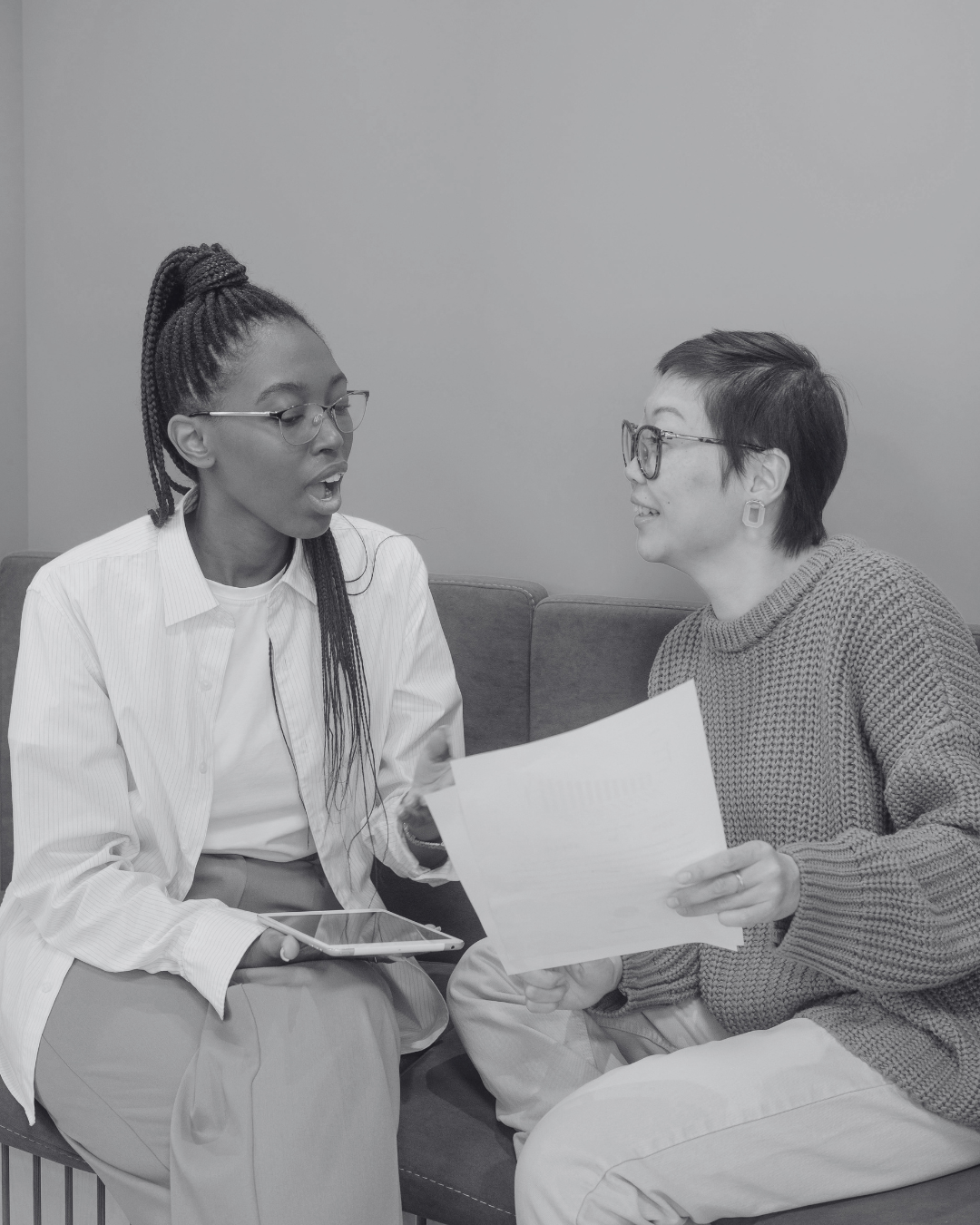 Therapist and client engaged in a supportive, collaborative conversation during a feminist and social justice informed therapy session